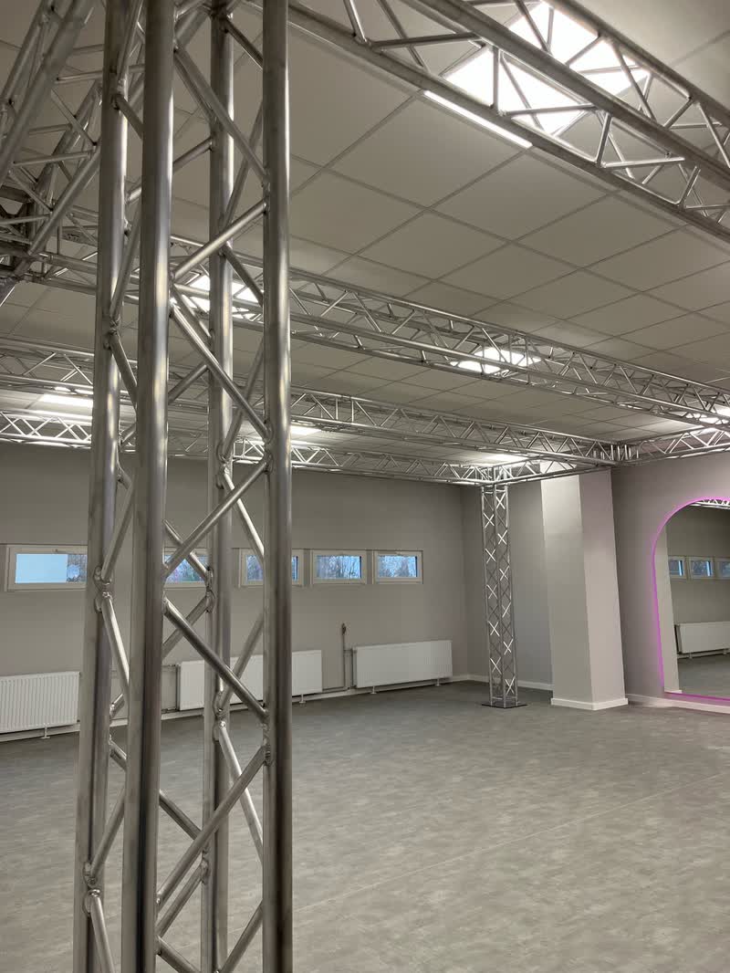 Aluminiowa kratownica na słupach pod sufitem pustej sali